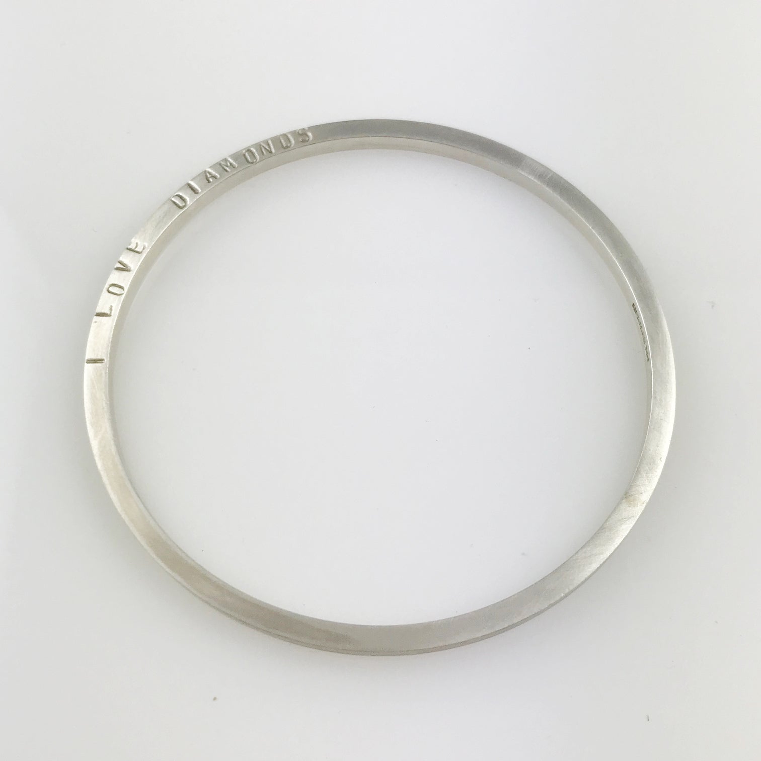 Silver round bangle with the words 'I LOVE DIAMONDS'